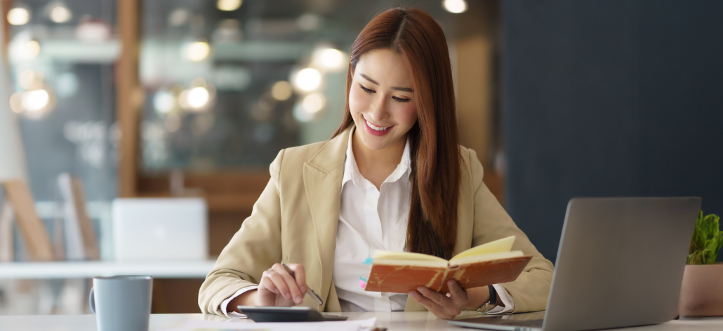 Business woman at a table with a calculator and notebook