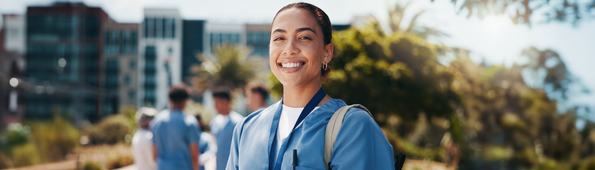 Nursing student smiling outside buildings
