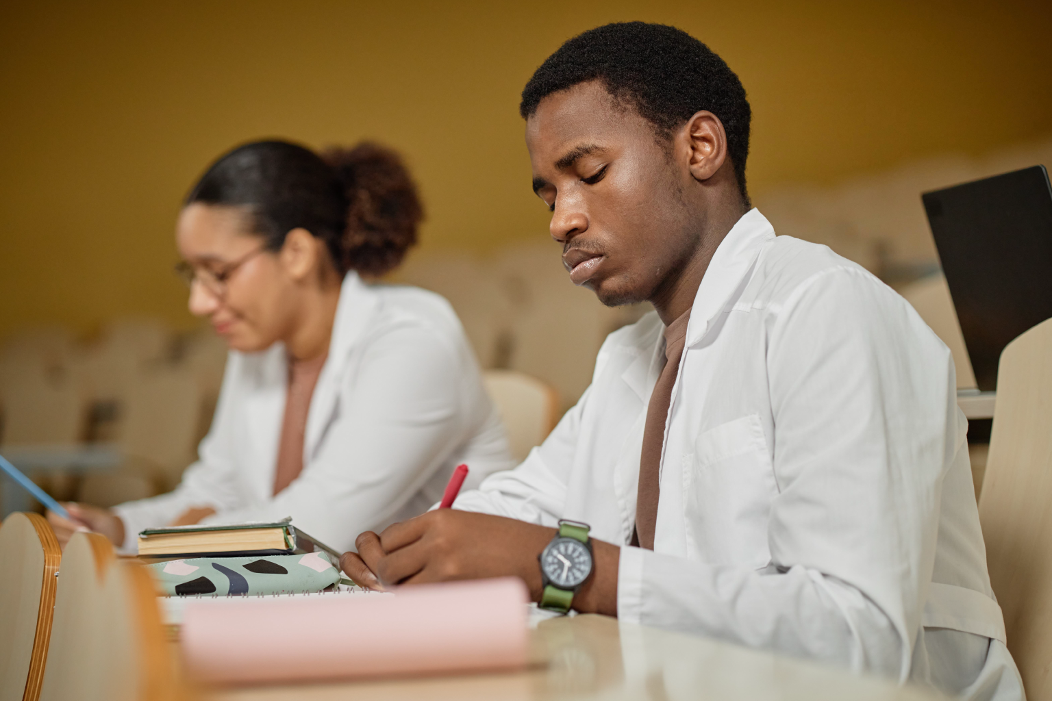 Medical students take notes in lecture hall