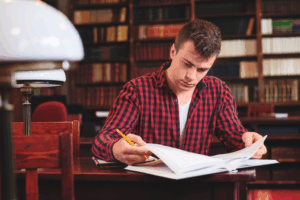Student in red plain studying in a library