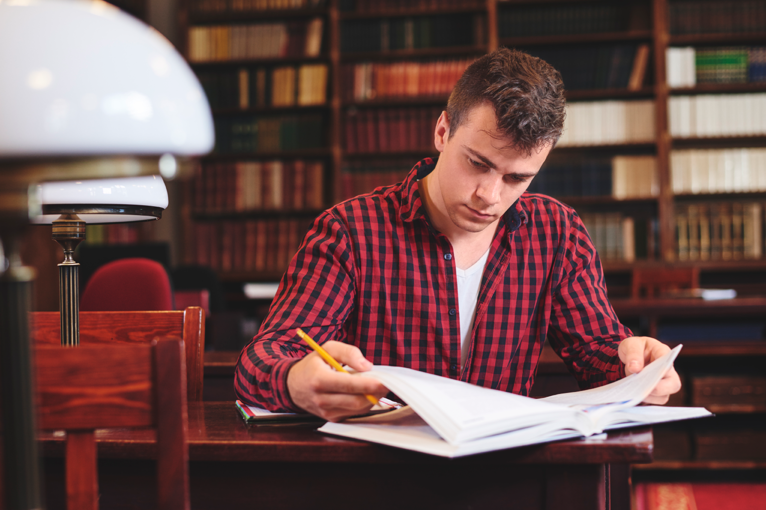 Student in red plain studying in a library