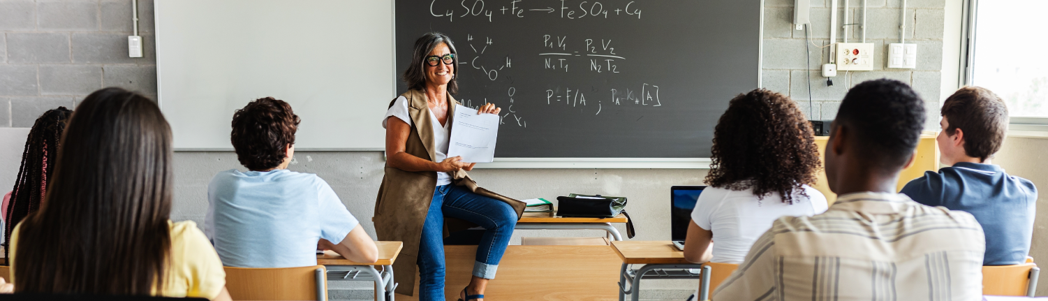 Teacher smiling while presenting something to her class